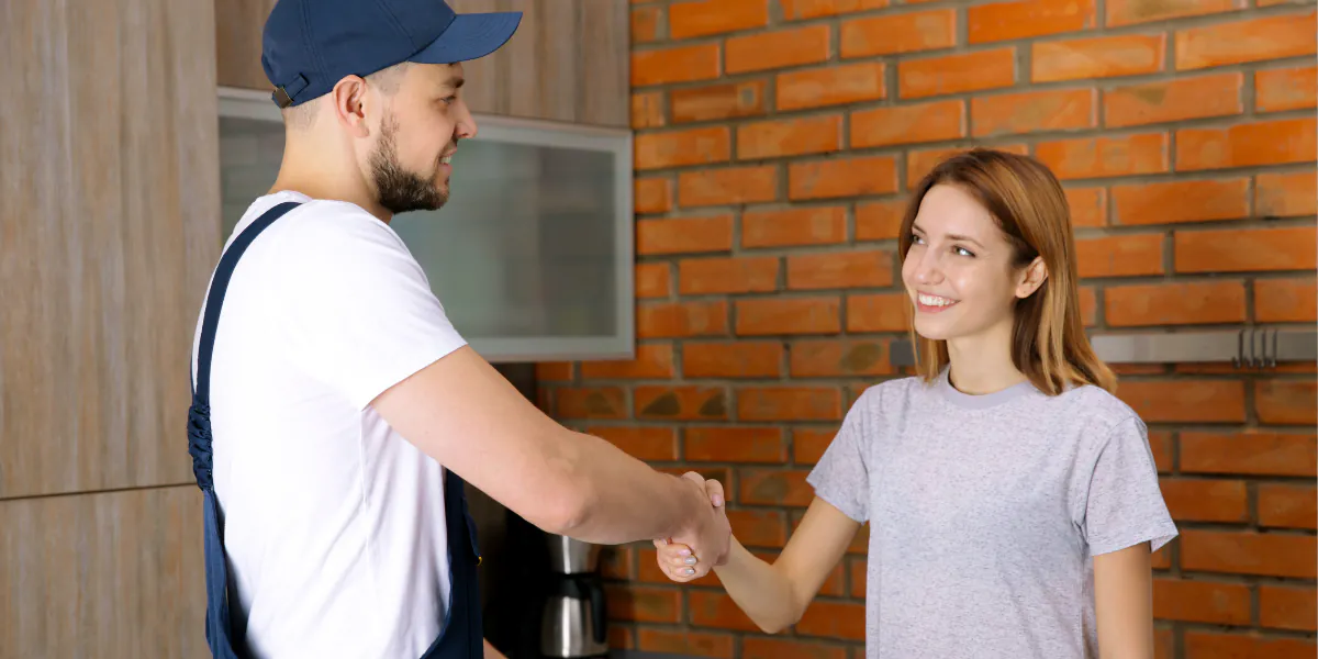 Customer shaking hand with HVAC technician outside