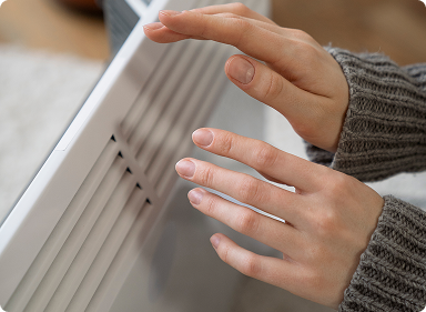 Person's hands are held close to a furnace to stay warm.