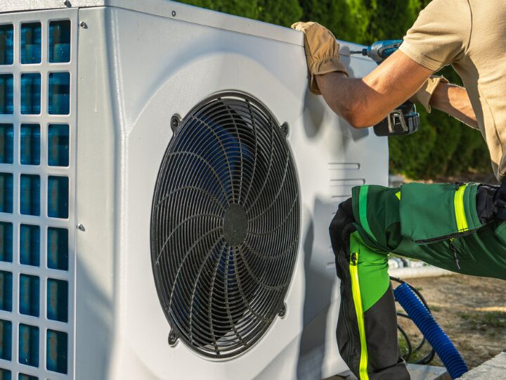 A worker fixing an AC unit outside
