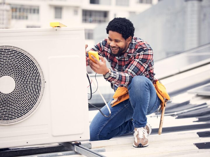 Man checking heat pump outside