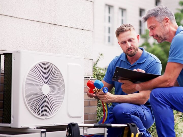 Man checking heat pump outside