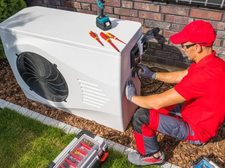 Man in red repairing heat pump