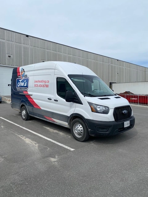 Photo of a Joe's Heating and Air Conditioning company truck in the parking lot.