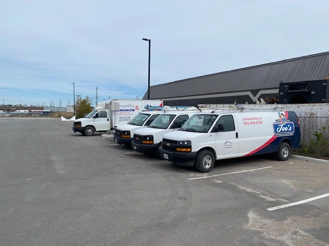 Row of Joe's Heating and Air Conditioning trucks in the parking lot