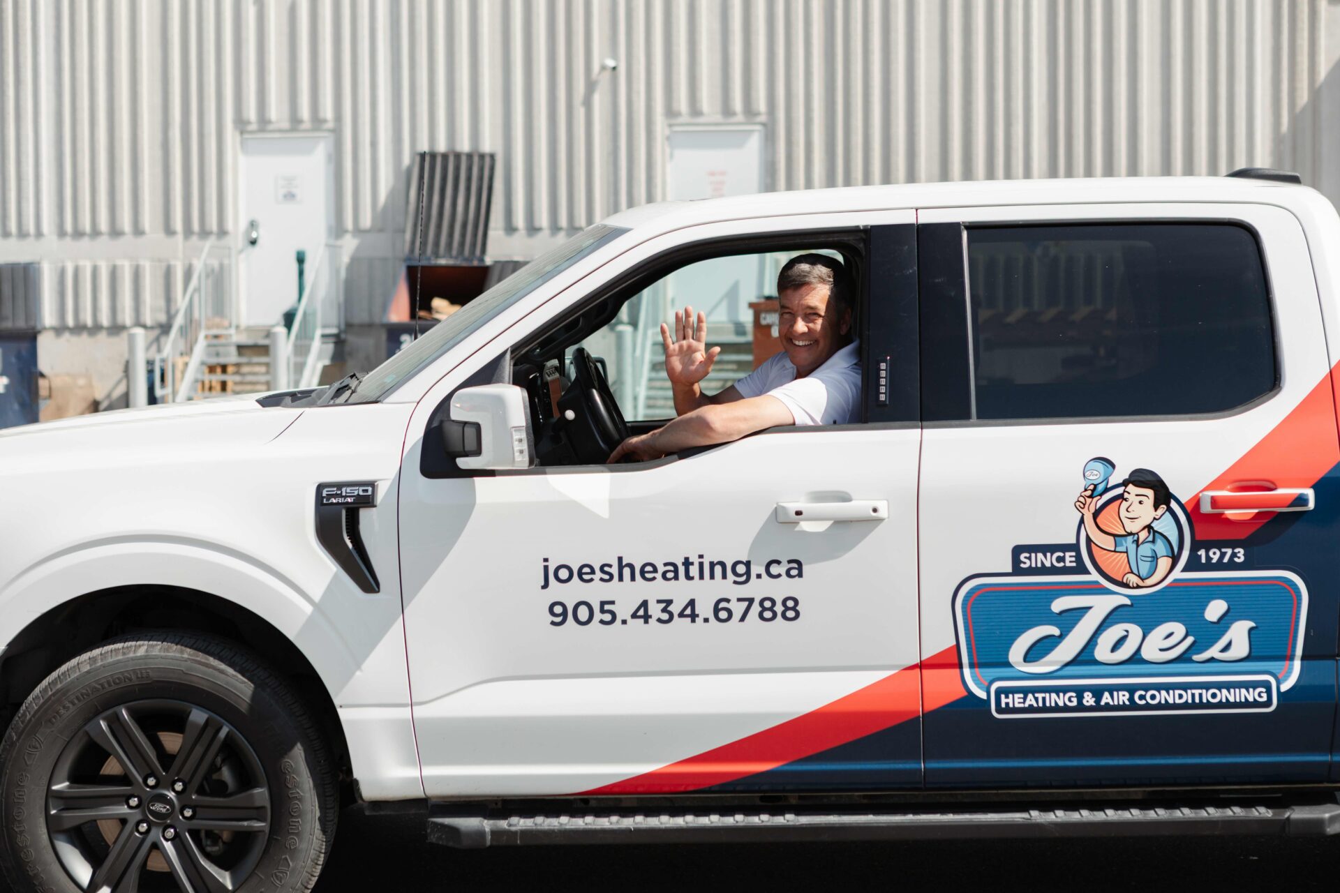 Joe's Heating owner waving from company truck