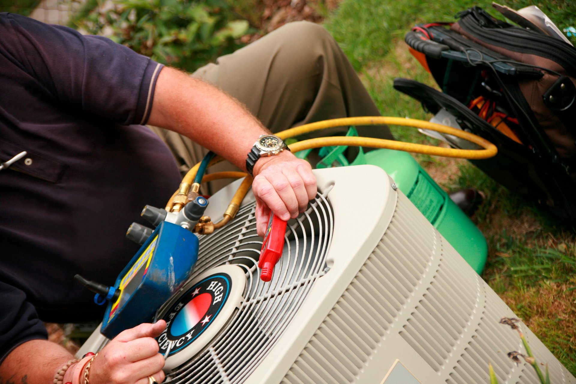 repairman fixing air conditioner outside a house