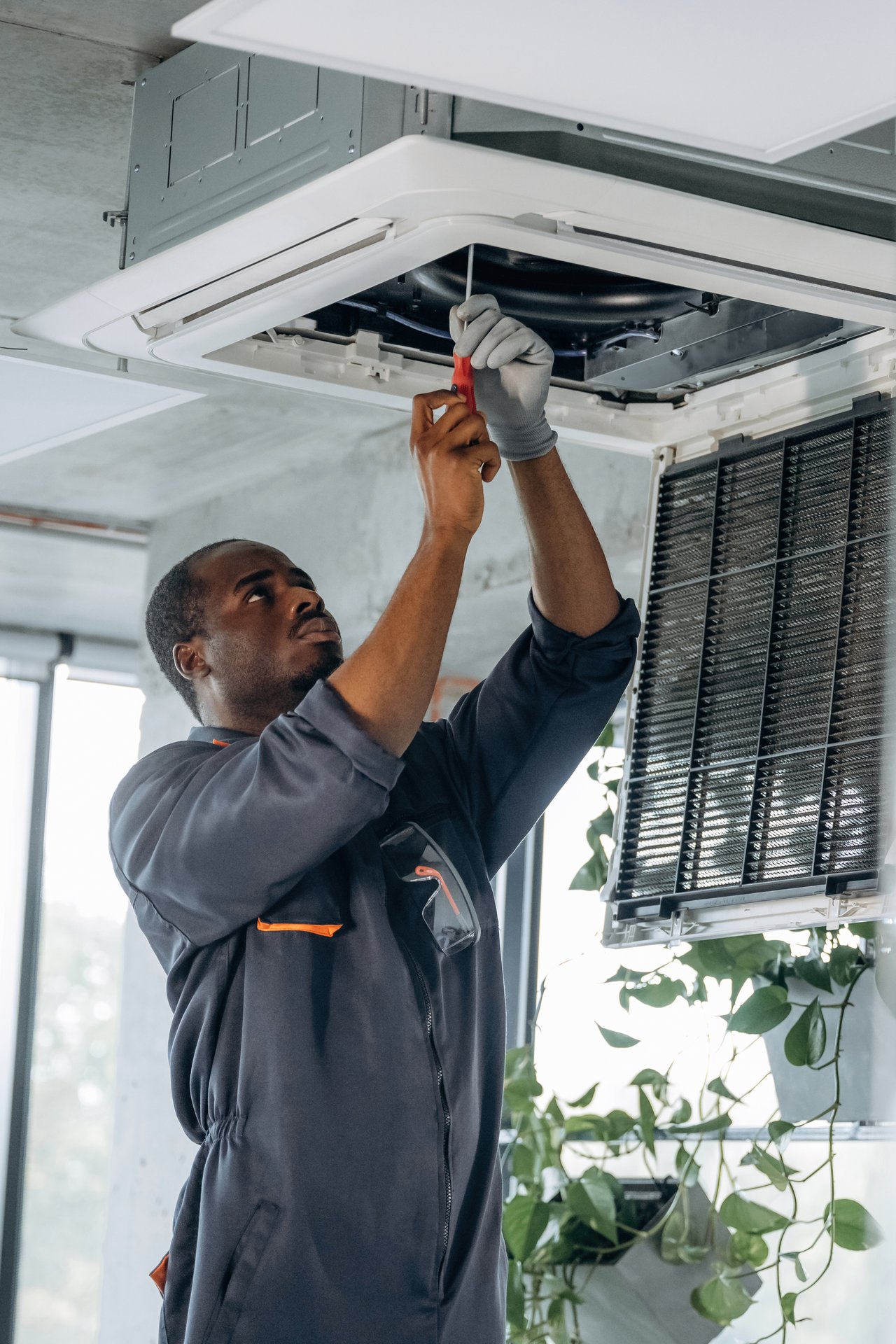 A worker fixing an overhead ceiling unit